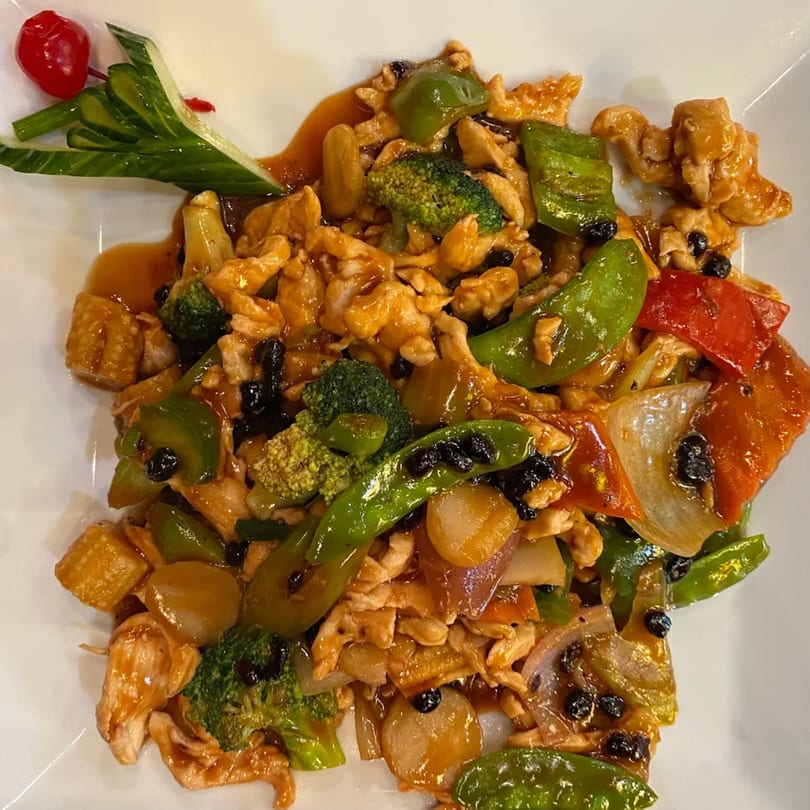 New Hong Kong House's chicken stir-fry with broccoli, peppers, and black beans, garnished with cucumber and a cherry.